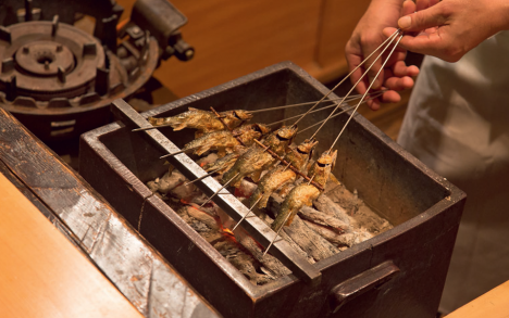 Grilling&nbsp;ayu&nbsp;over&nbsp;bincho-tan&nbsp;charcoal.
